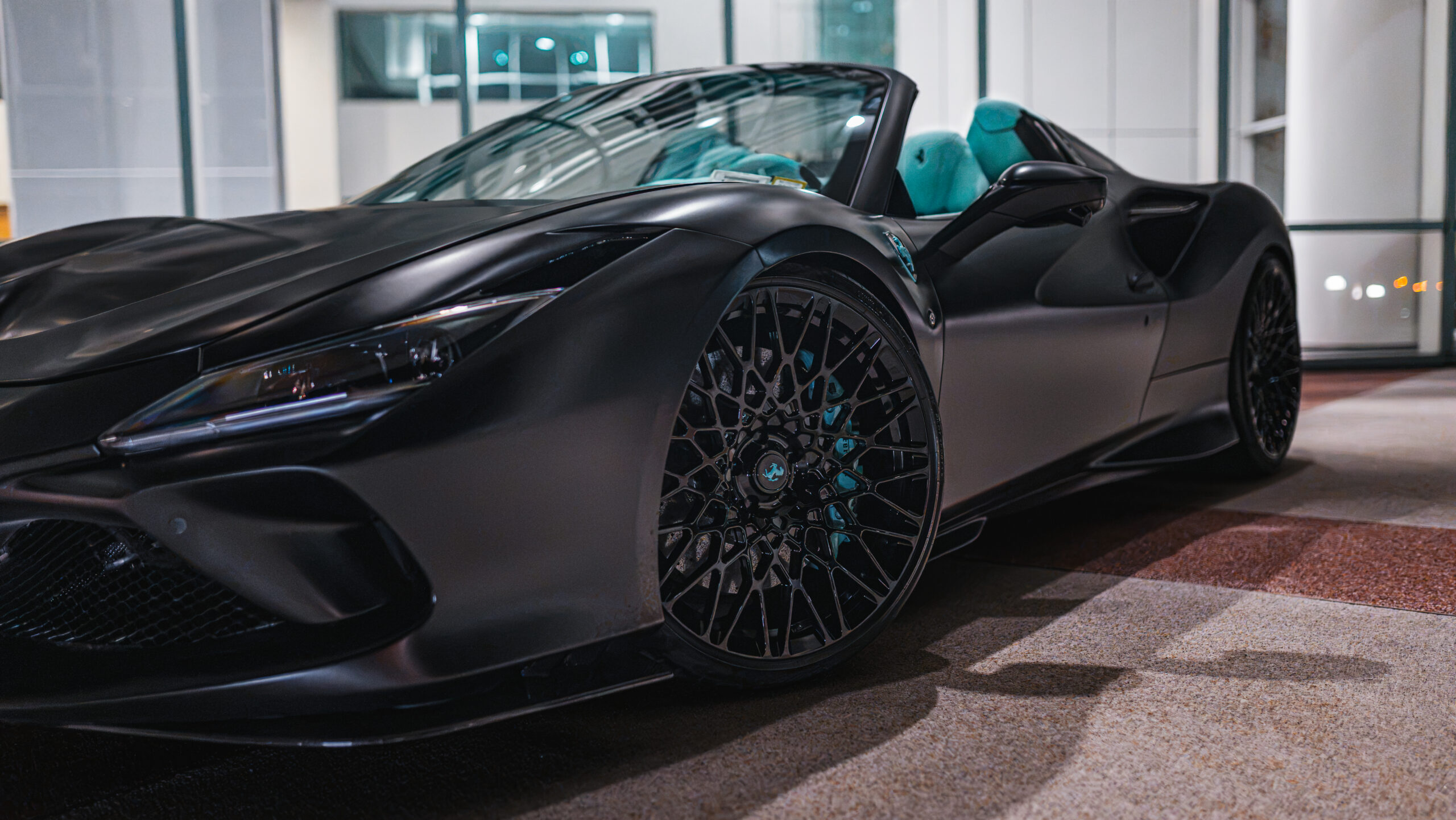 Black Ferrari F8 Spider photographed from a low front-side angle